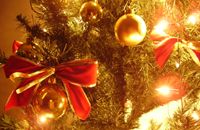 Beleuchteter Weihnachtsbaum mit Kugeln und Schleife